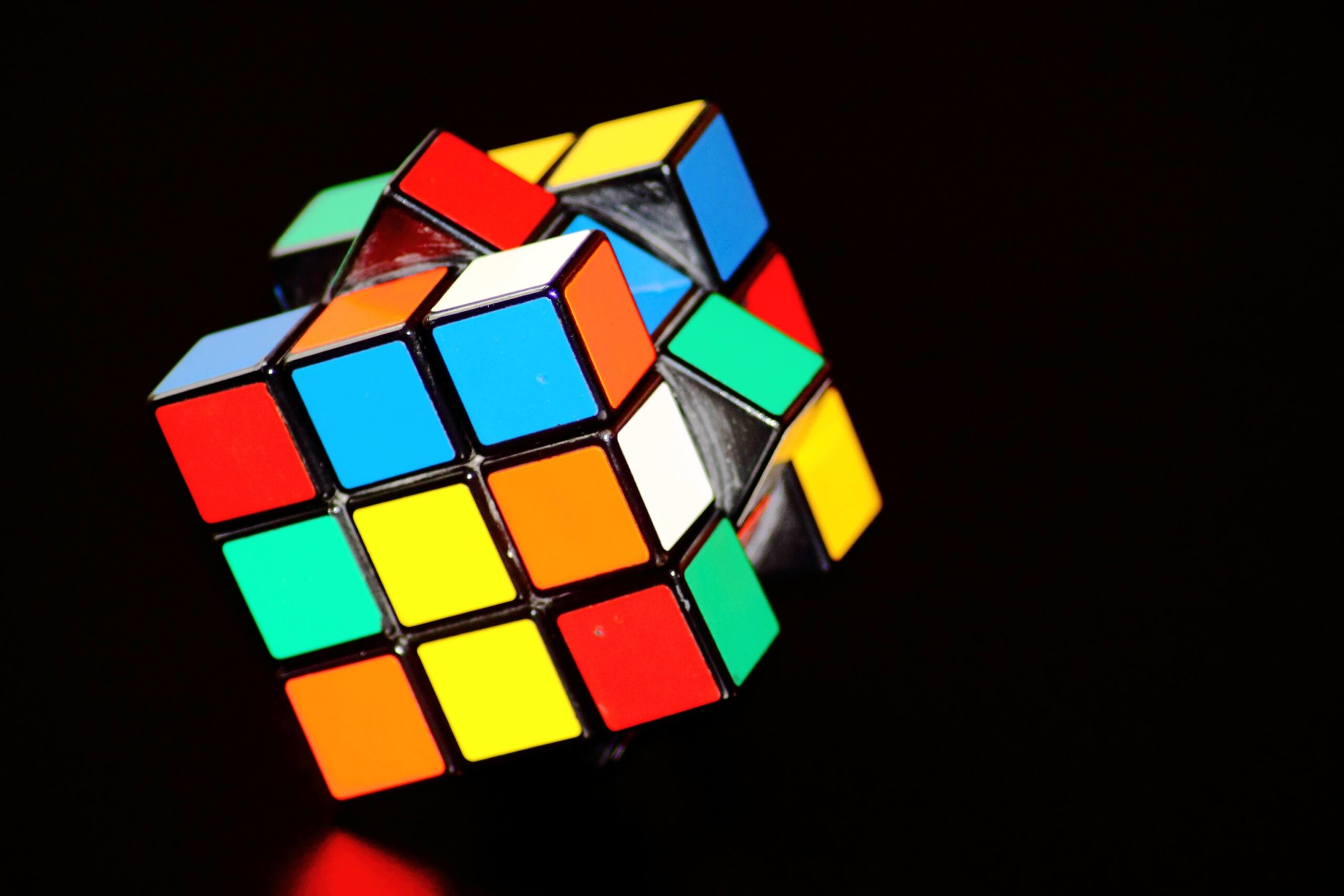 Unsolved Rubik's Cube against black background