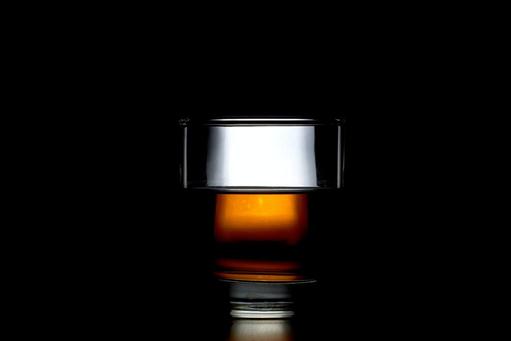 Glass of whiskey neat against black background
