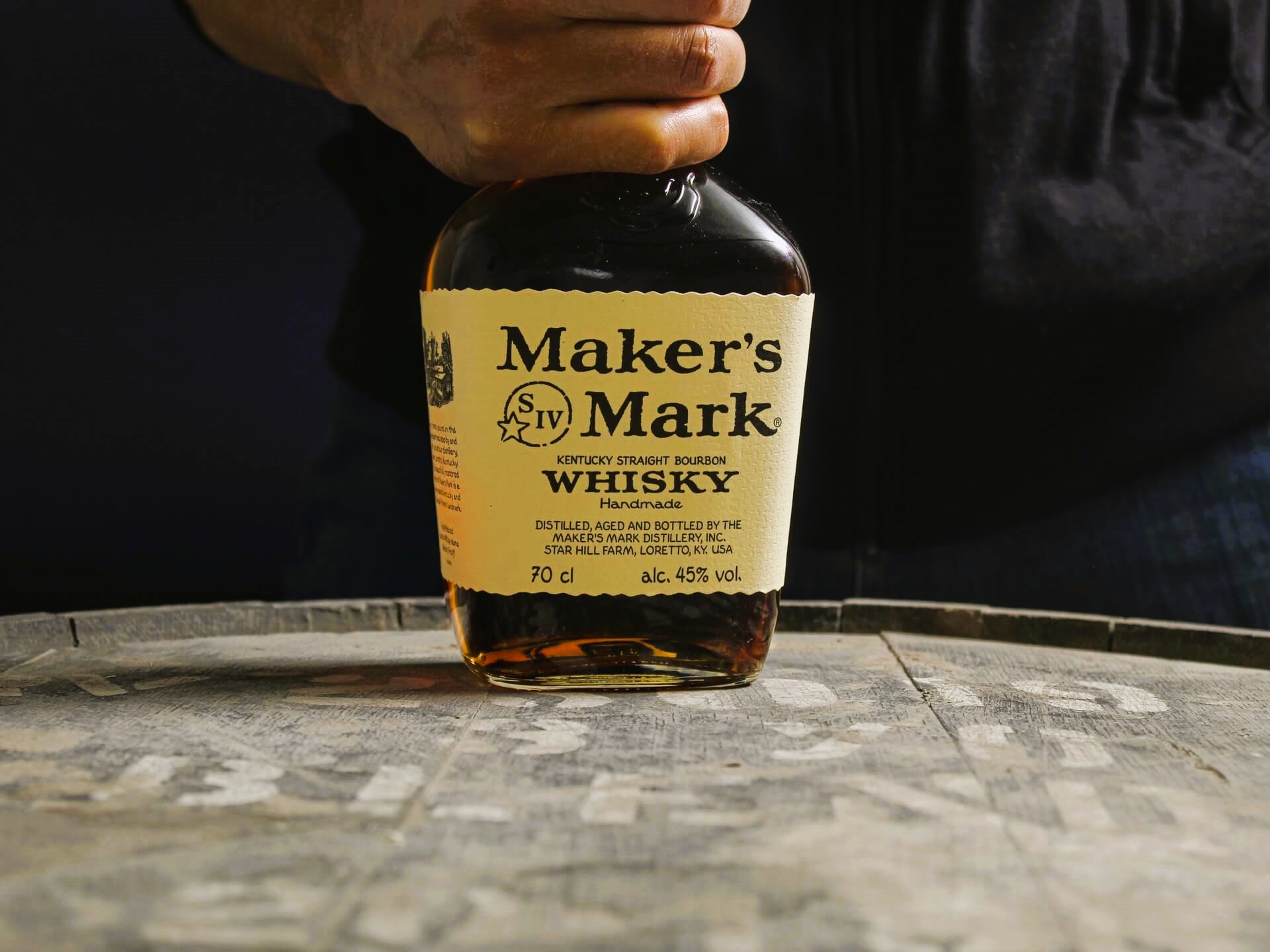 Maker's Mark bourbon bottle on top of barrel