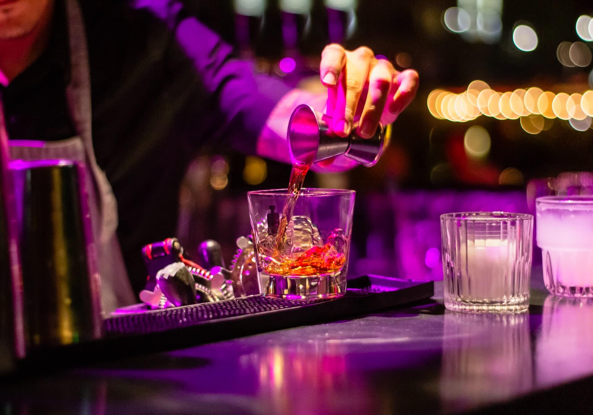 Closeup of bartender's hand pouring shot