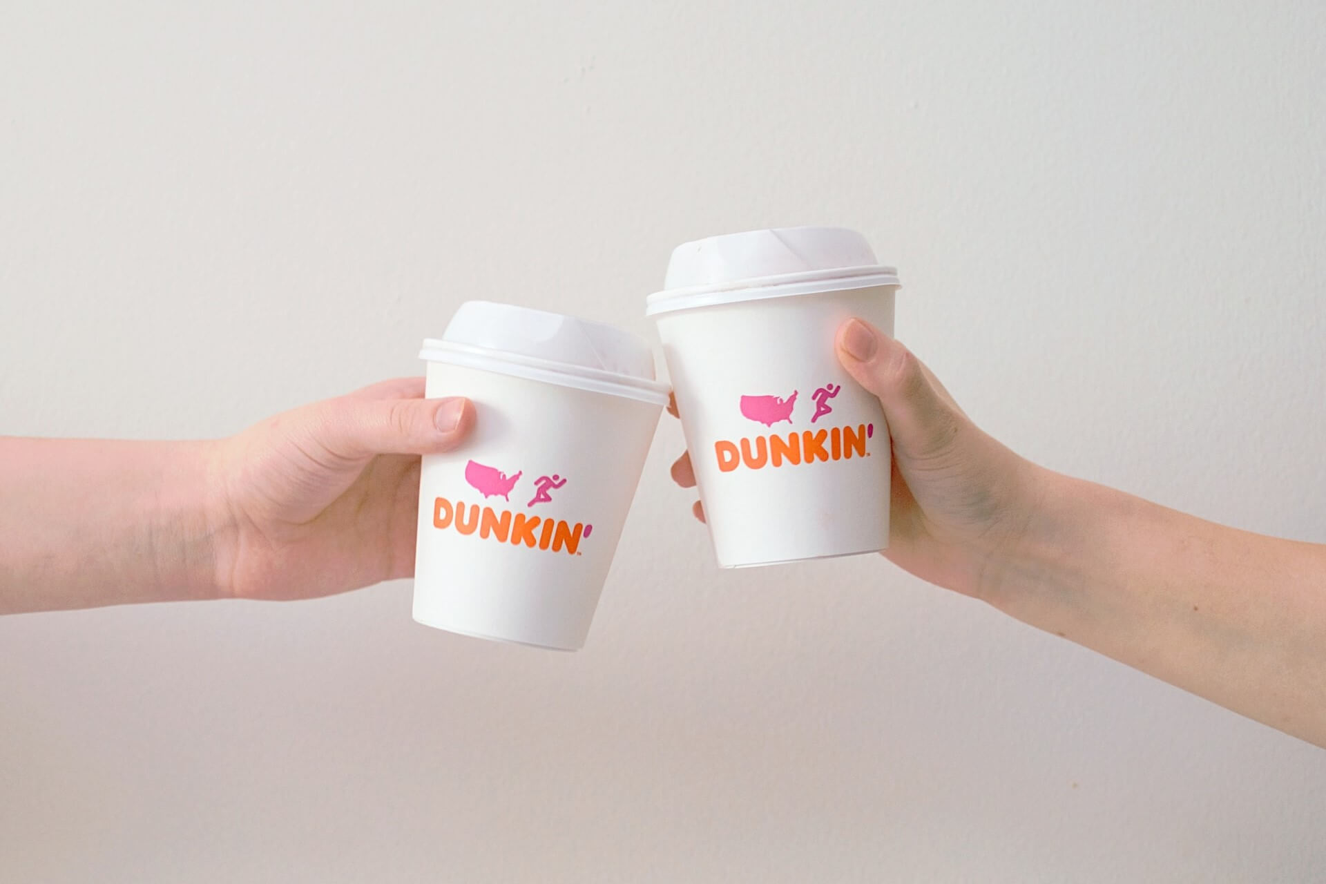 People toasting with Dunkin' Donuts cups