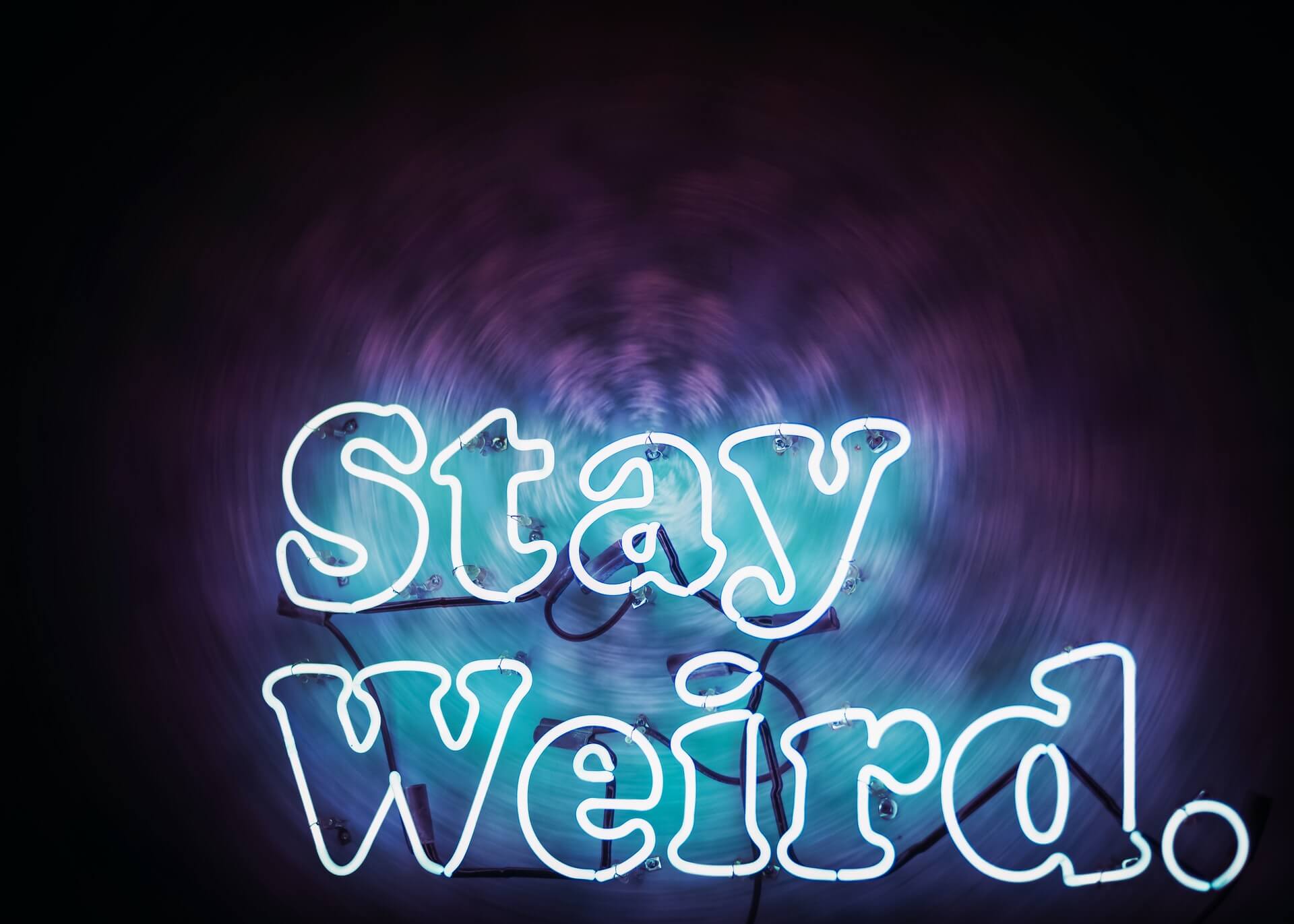 Stay Weird neon sign with purple background
