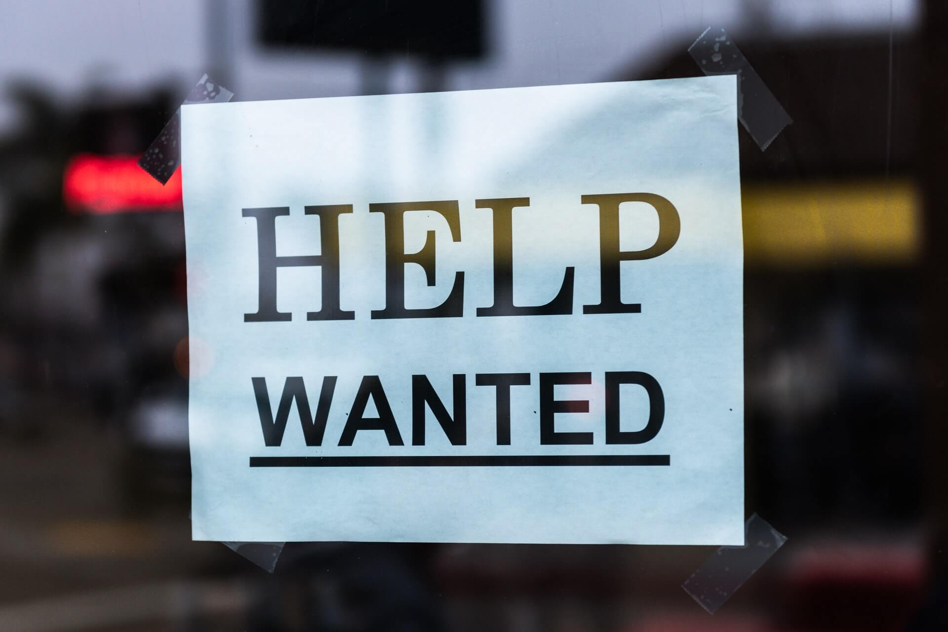 Help Wanted sign taped in window