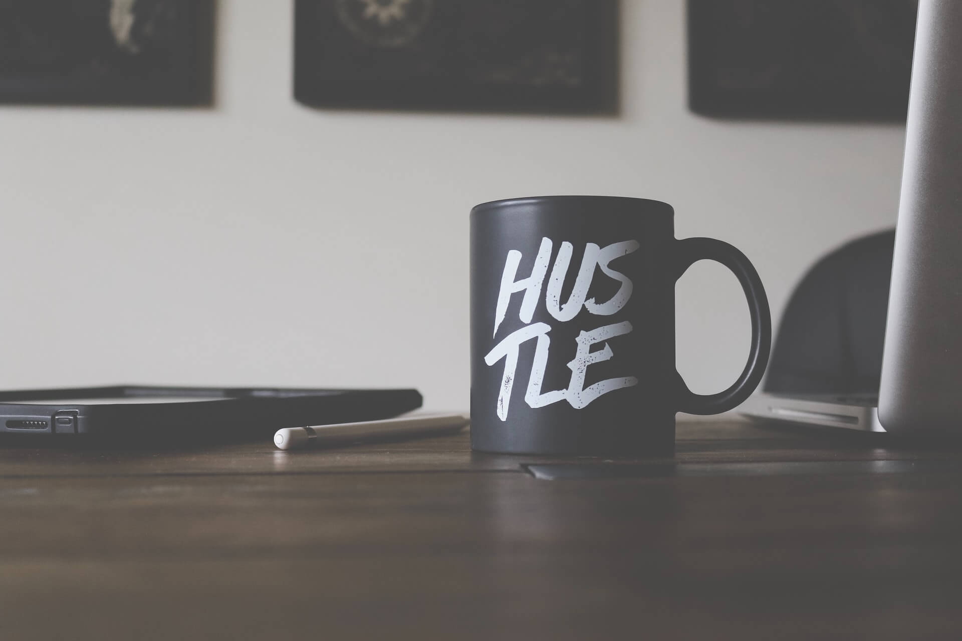 Black "Hustle" coffee cup on desk