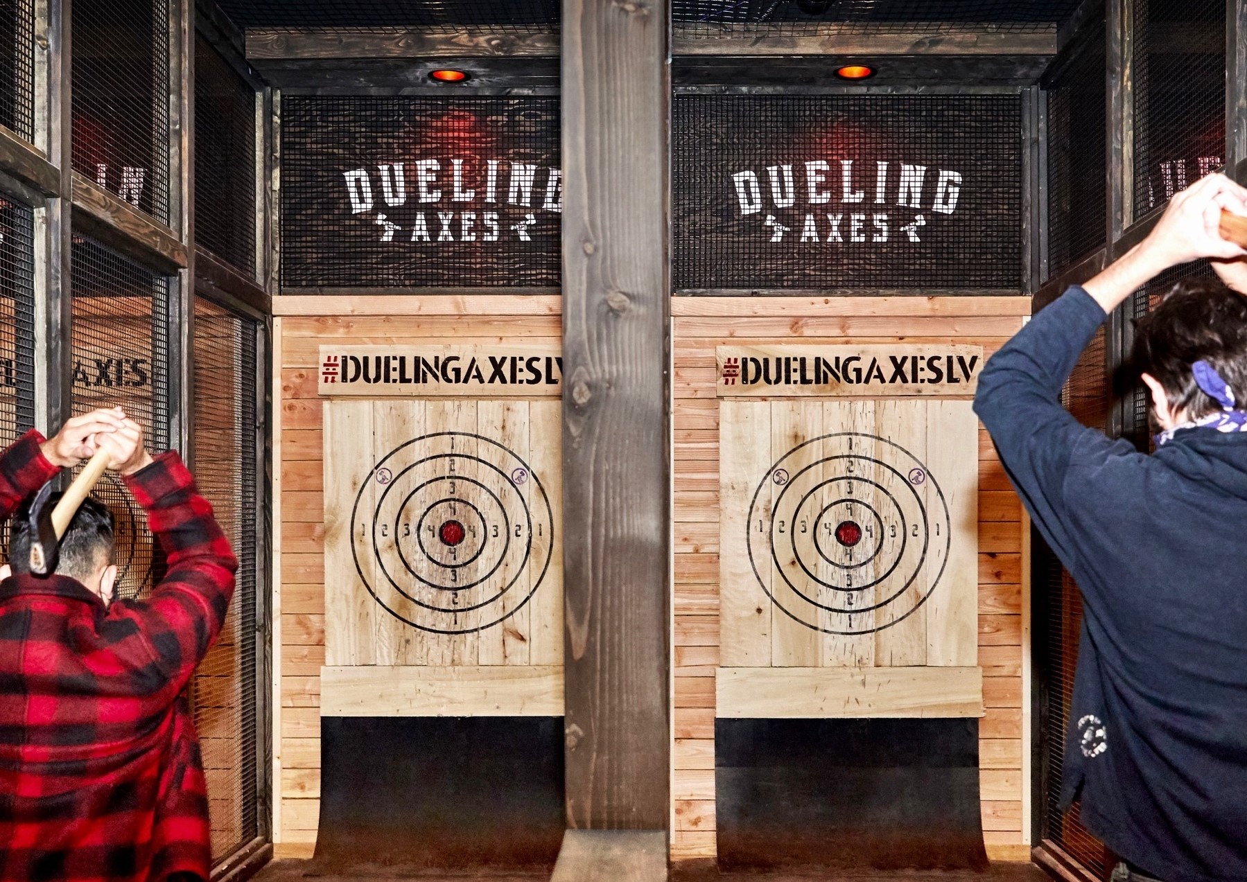 Two people throwing axes at Dueling Axes Las Vegas inside Area15