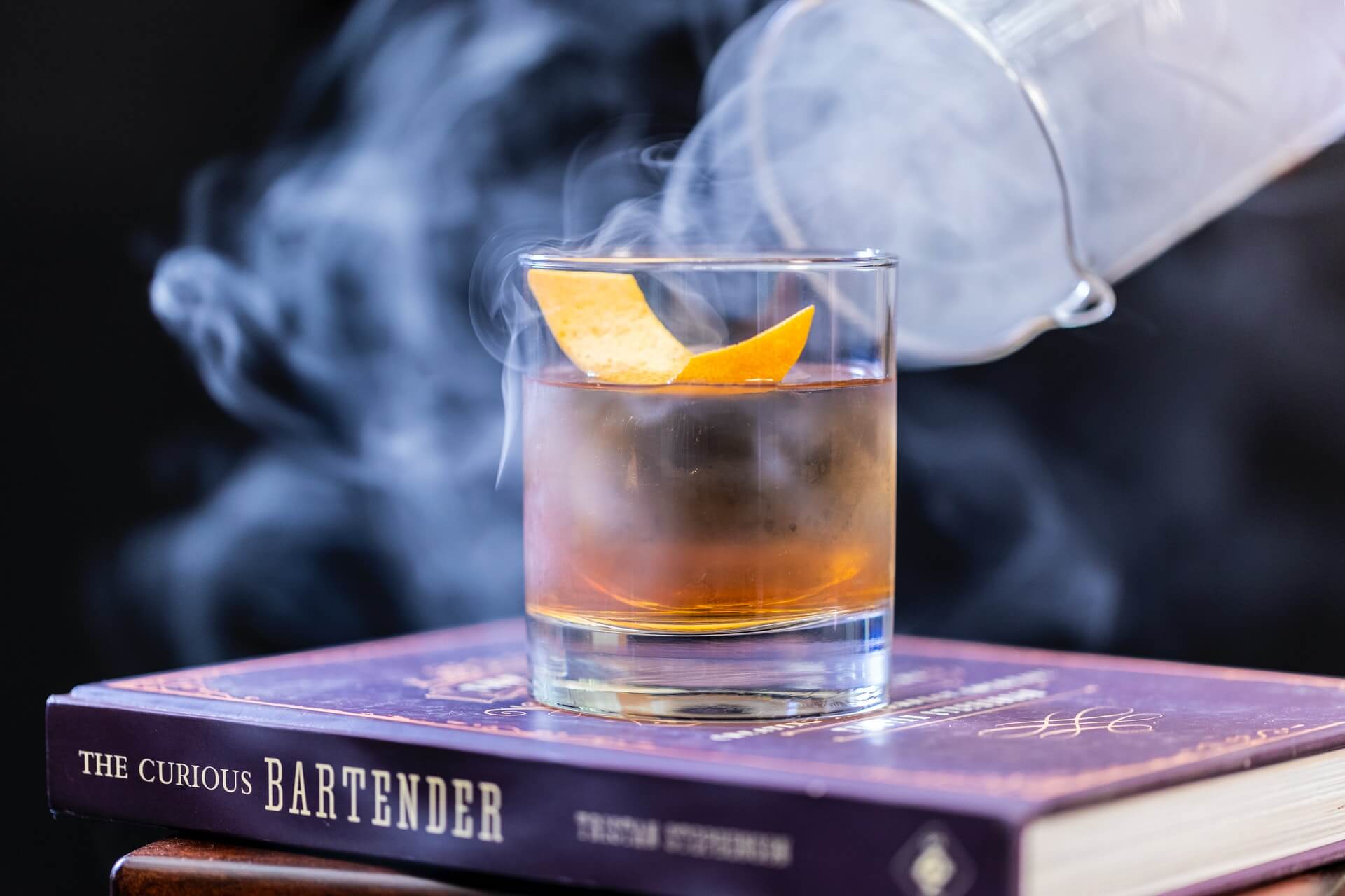 Cocktail and smoke on top stack of books