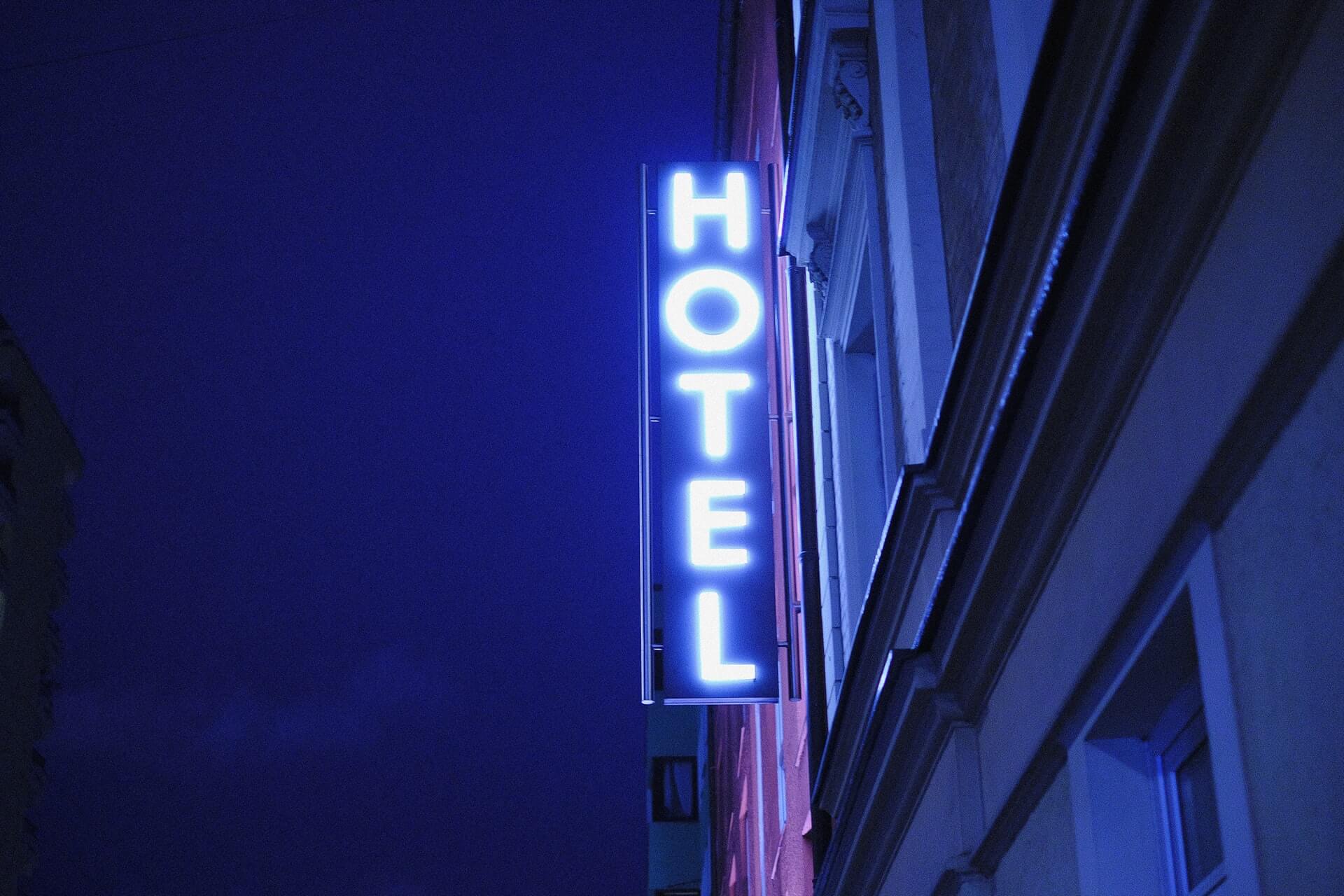 Lit neon hotel sign with blue and purple background