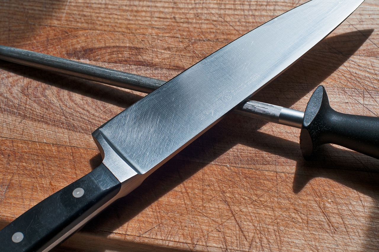 Chef's knife and honing rod crossed on cutting board