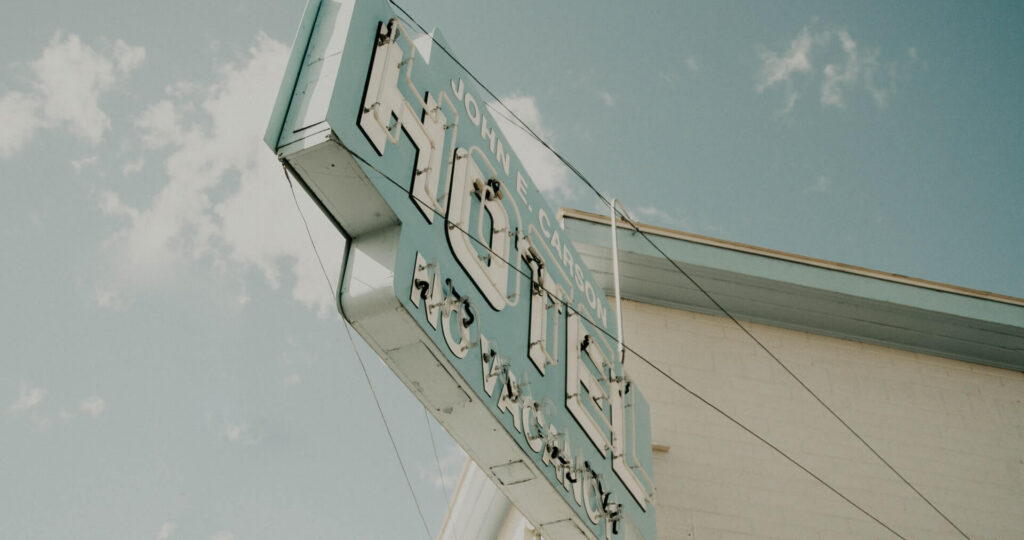Unlit hotel sign against blue sky background
