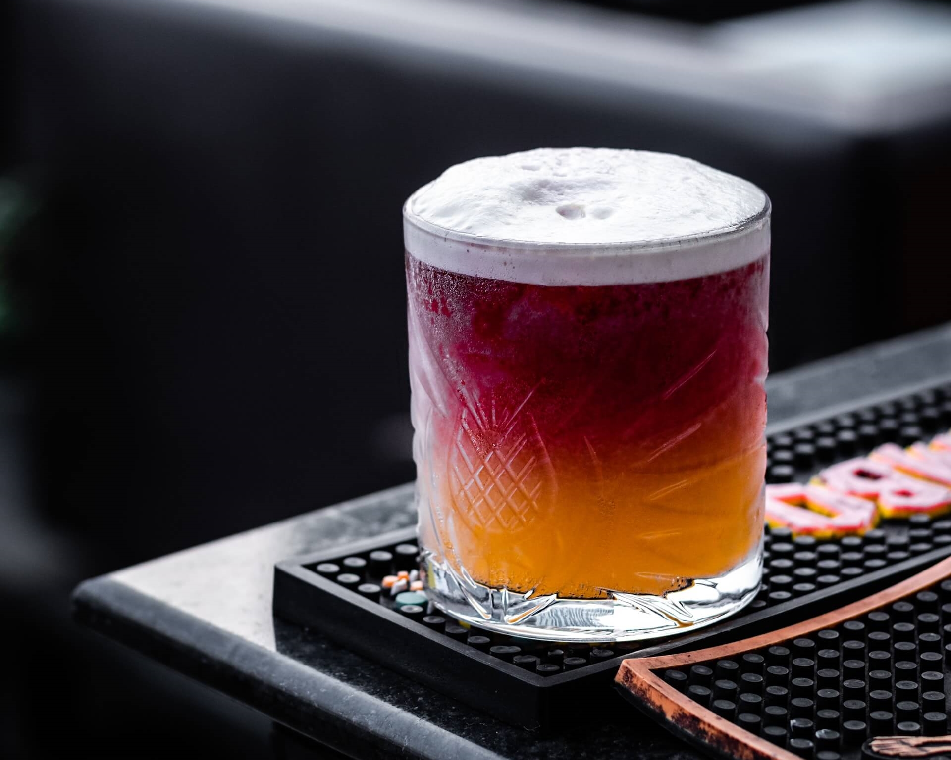 Cocktail on bar mat behind bar