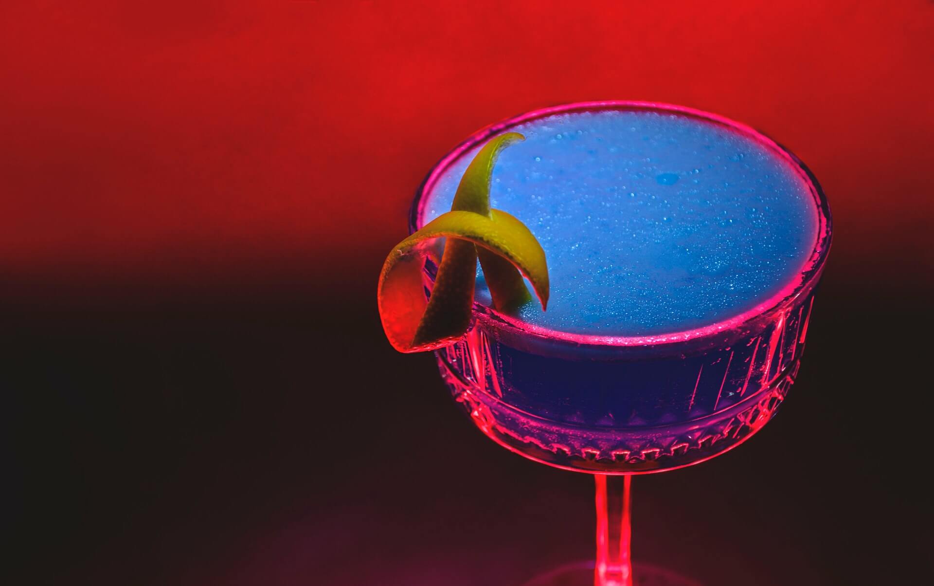 High contrast image of blue cocktail with lemon zest