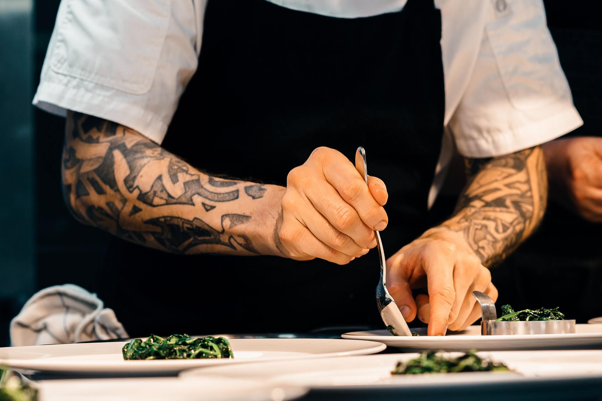 Chef plating greens on plates