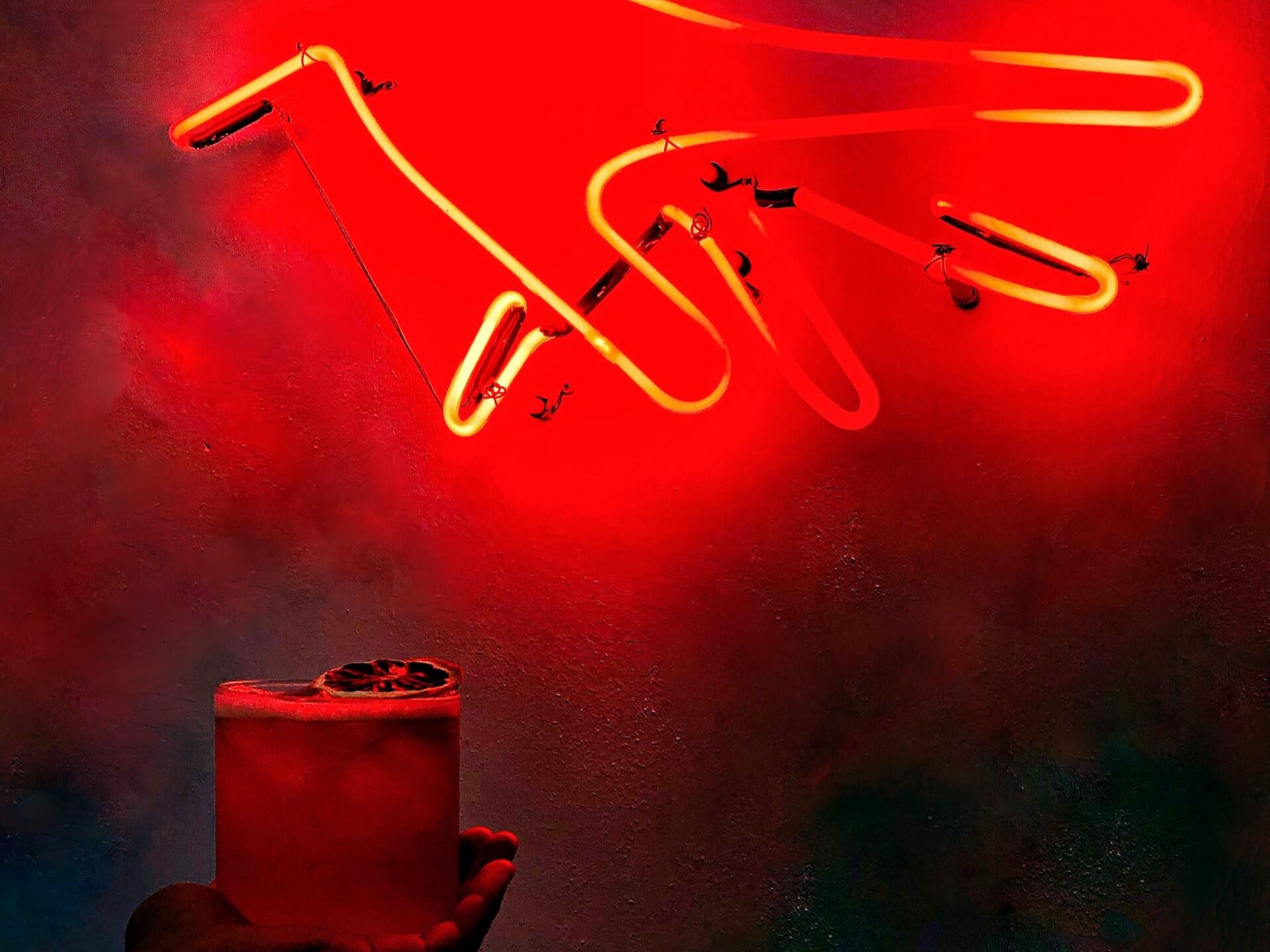 Red neon hand sign over a cocktail
