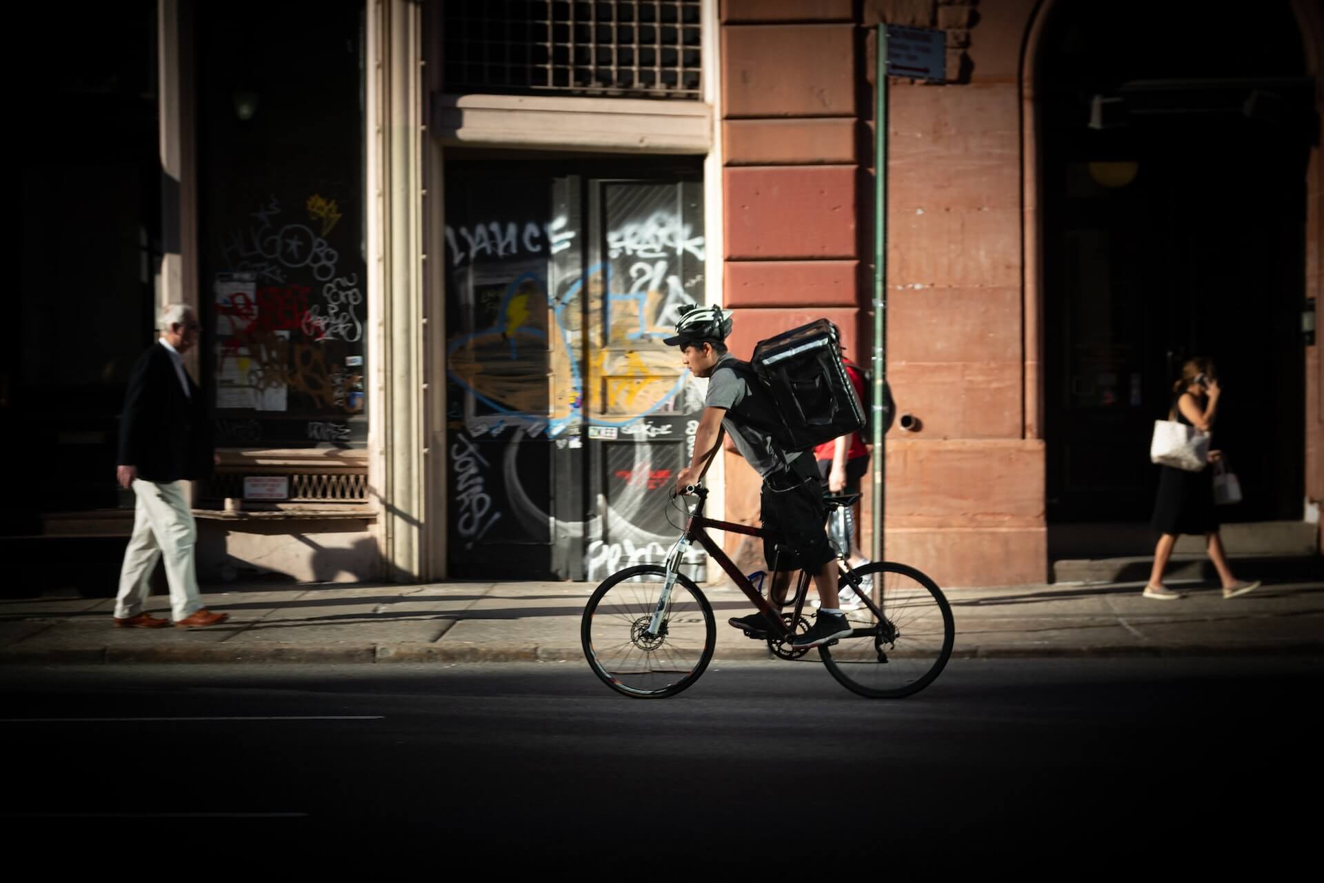 Delivery worker on bicycle on city street