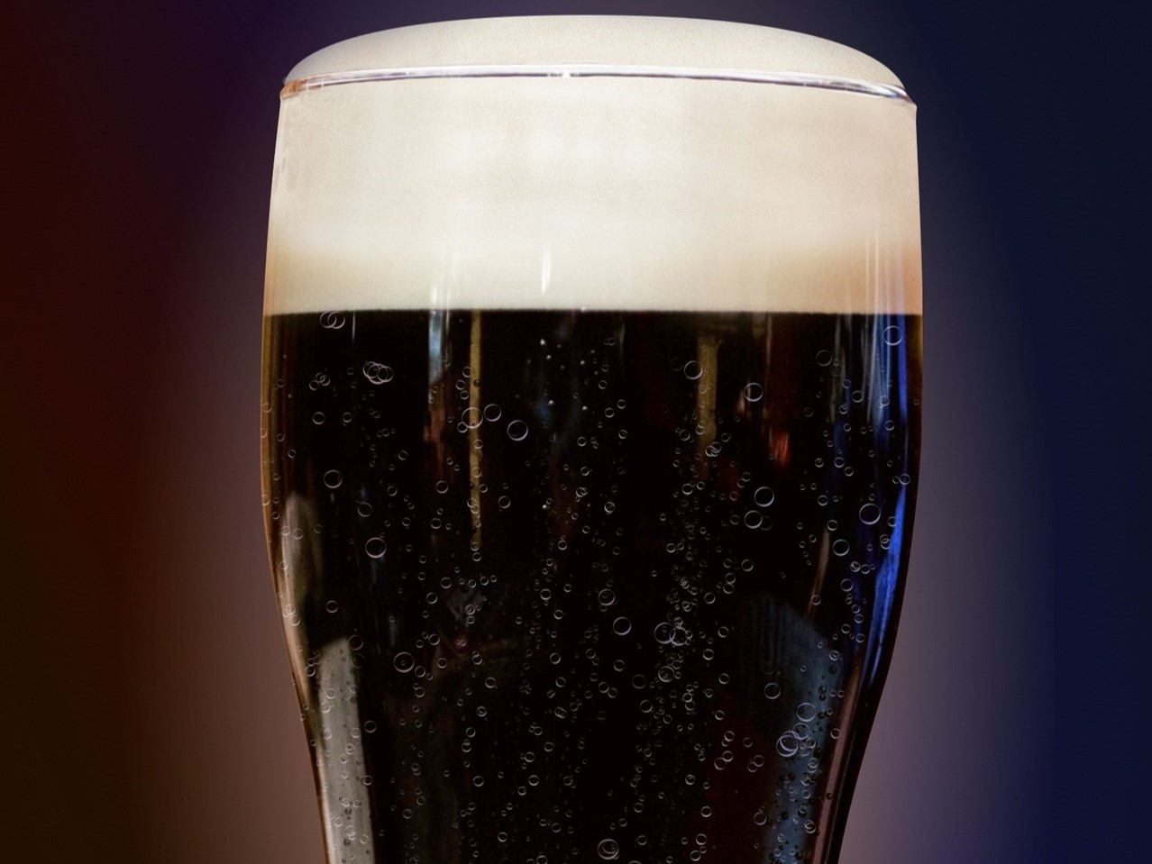 Closeup of dark beer with foamy head