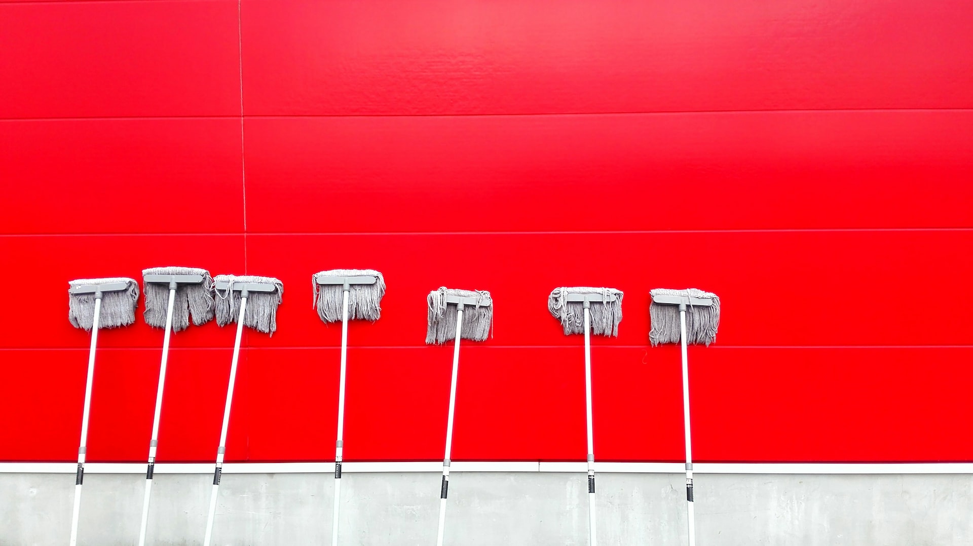 White mops against red and white wall
