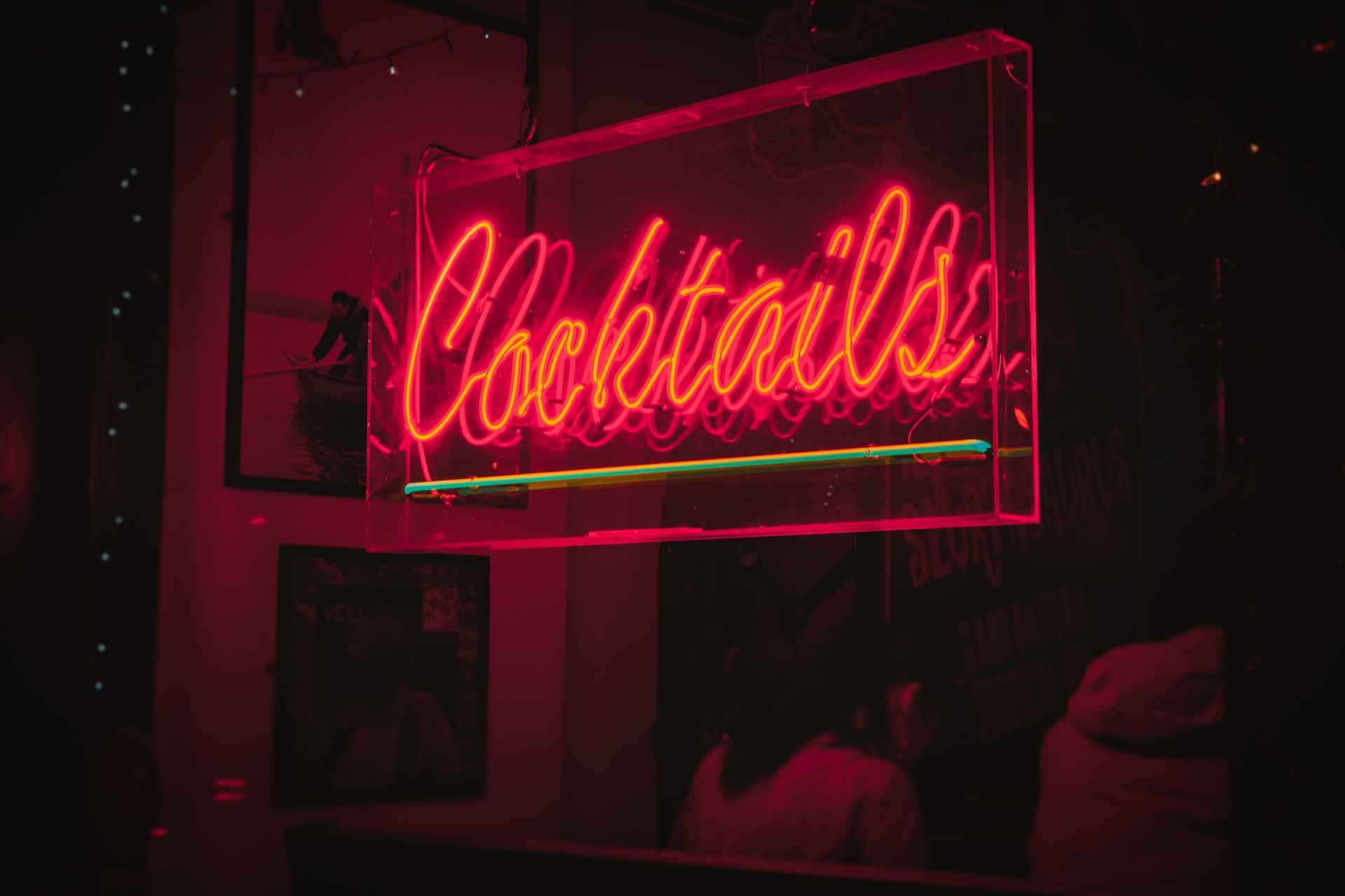Neon sign in red that reads "Cocktails"