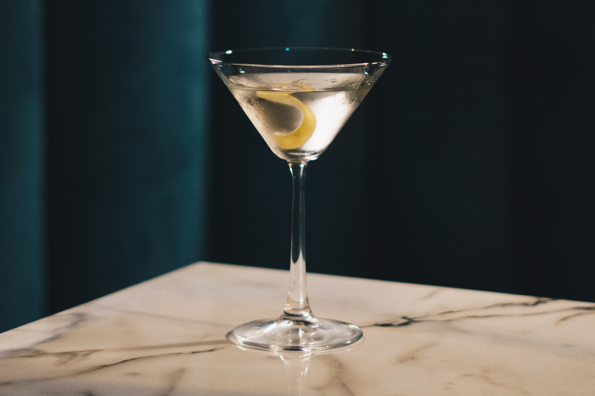 Martini with lemon twist on marble tabletop