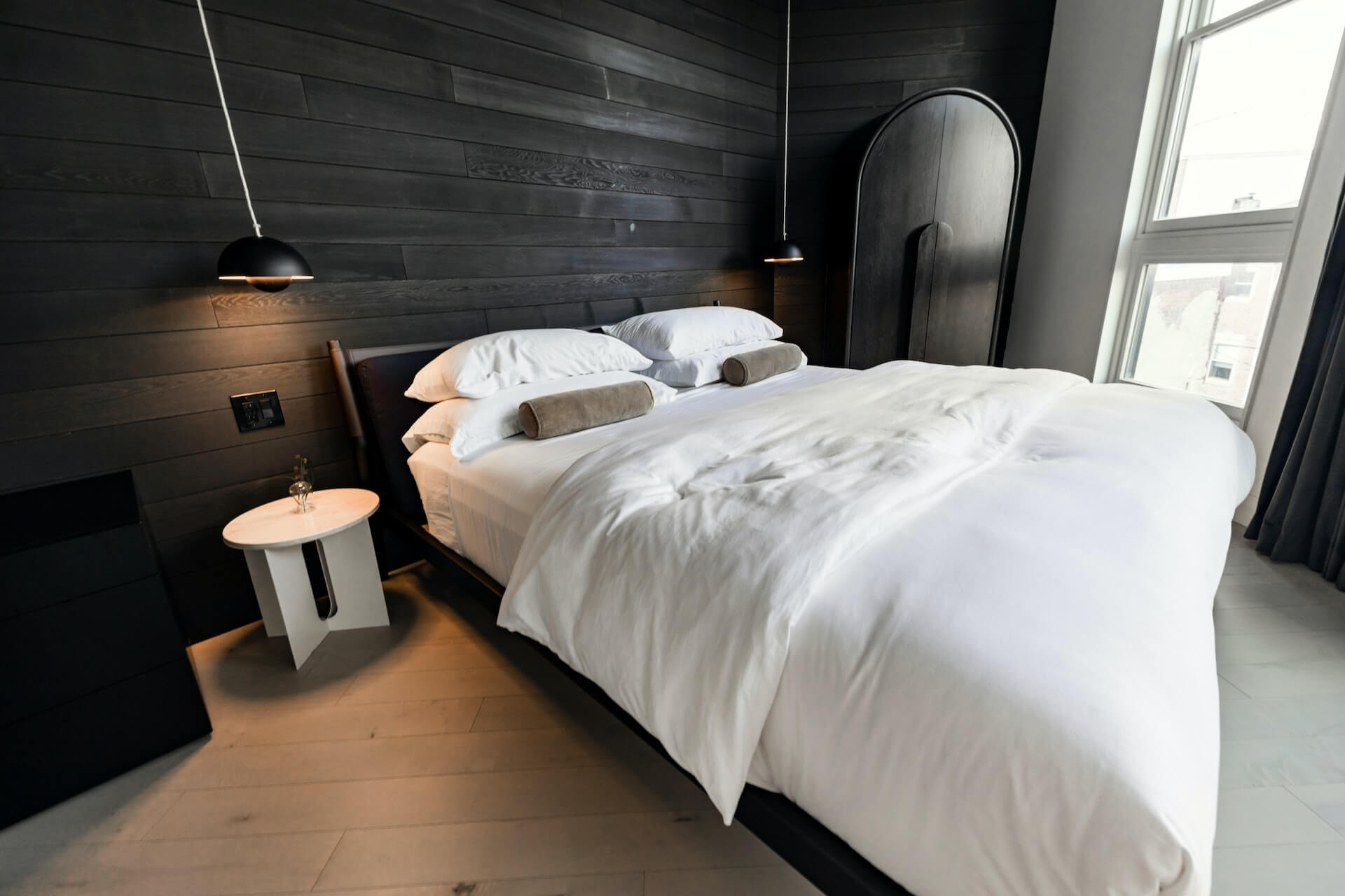 Boutique hotel room with black and white walls and linens