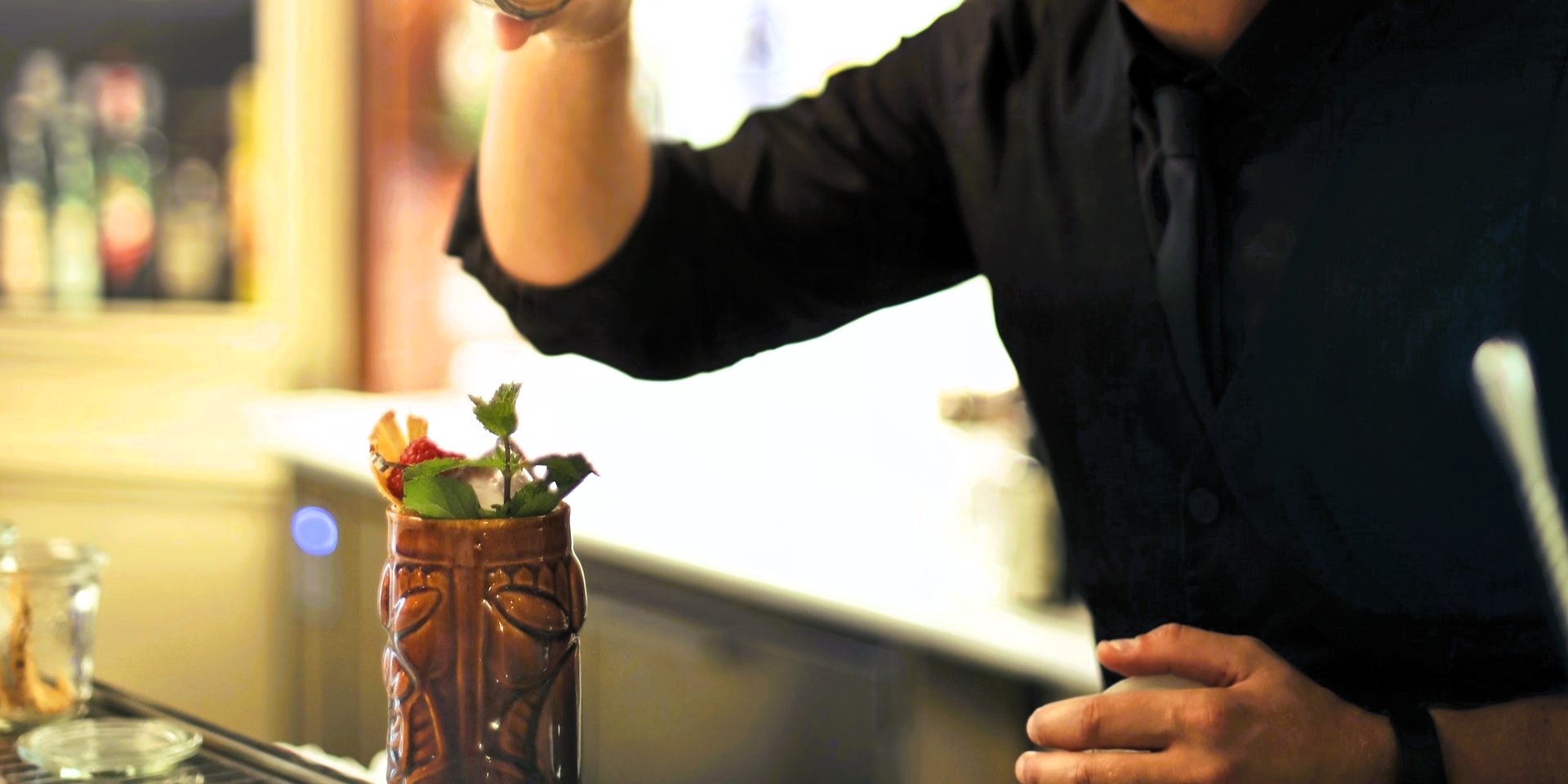 Bartender serving a tiki cocktail