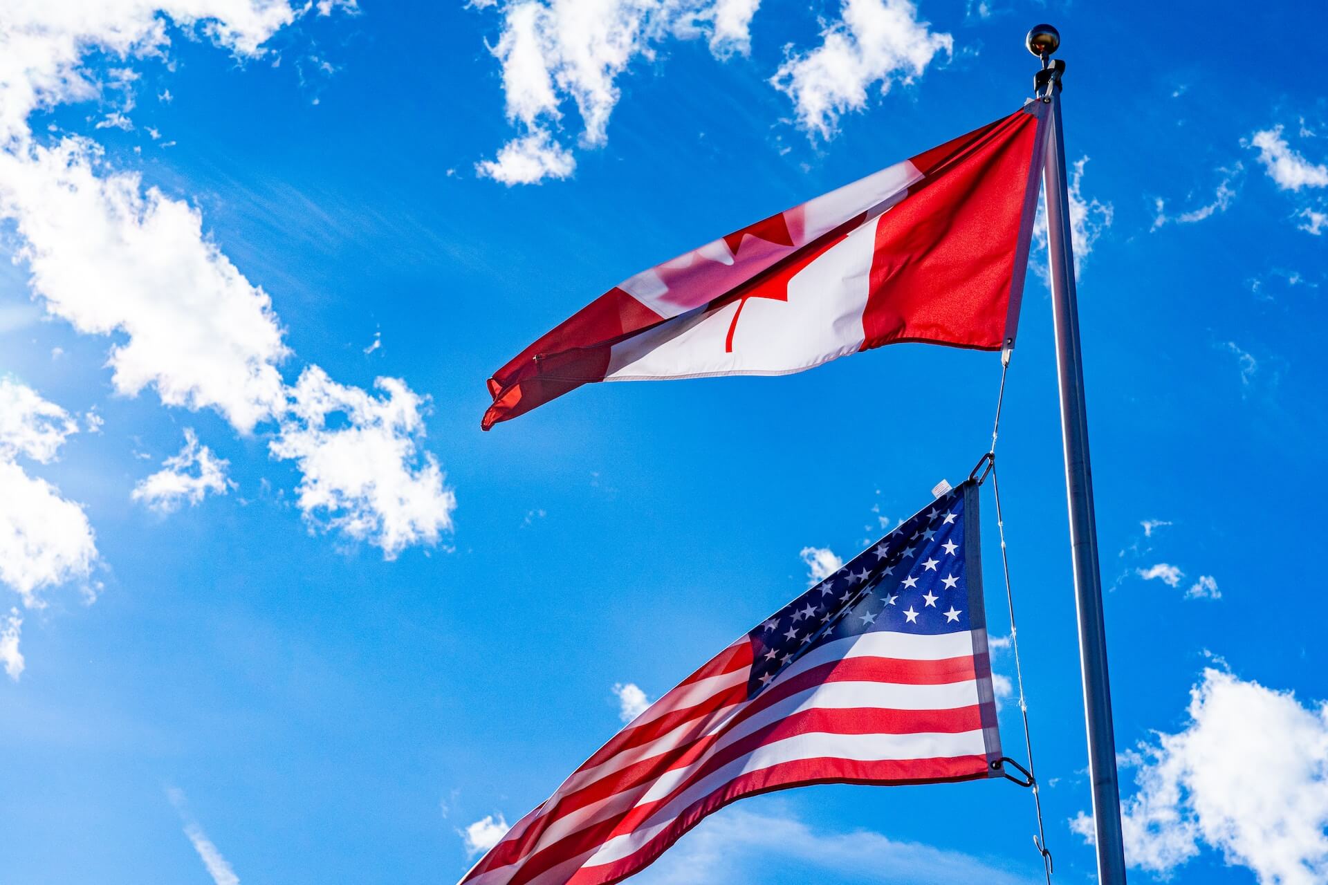 Canadian and America flags flying together