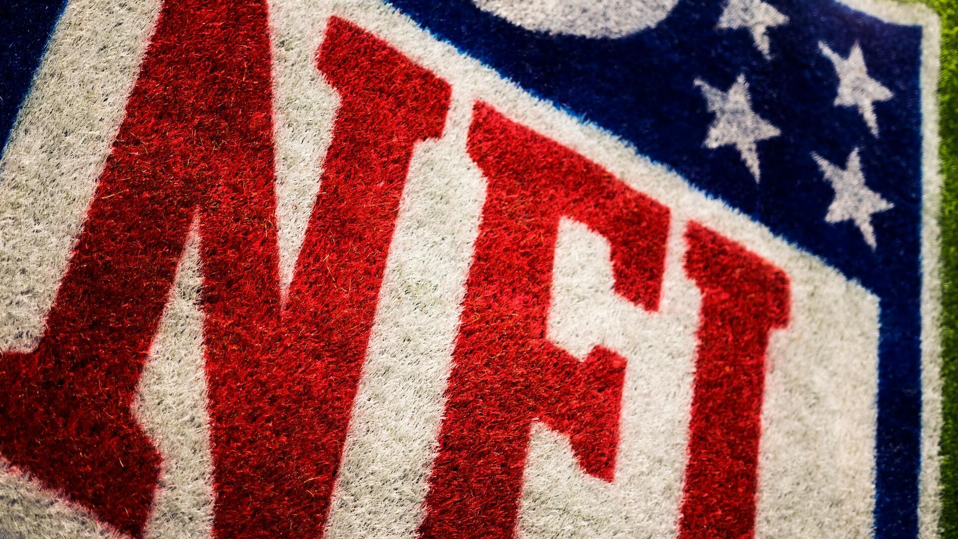 Closeup shot of the NFL logo painted onto turf or grass