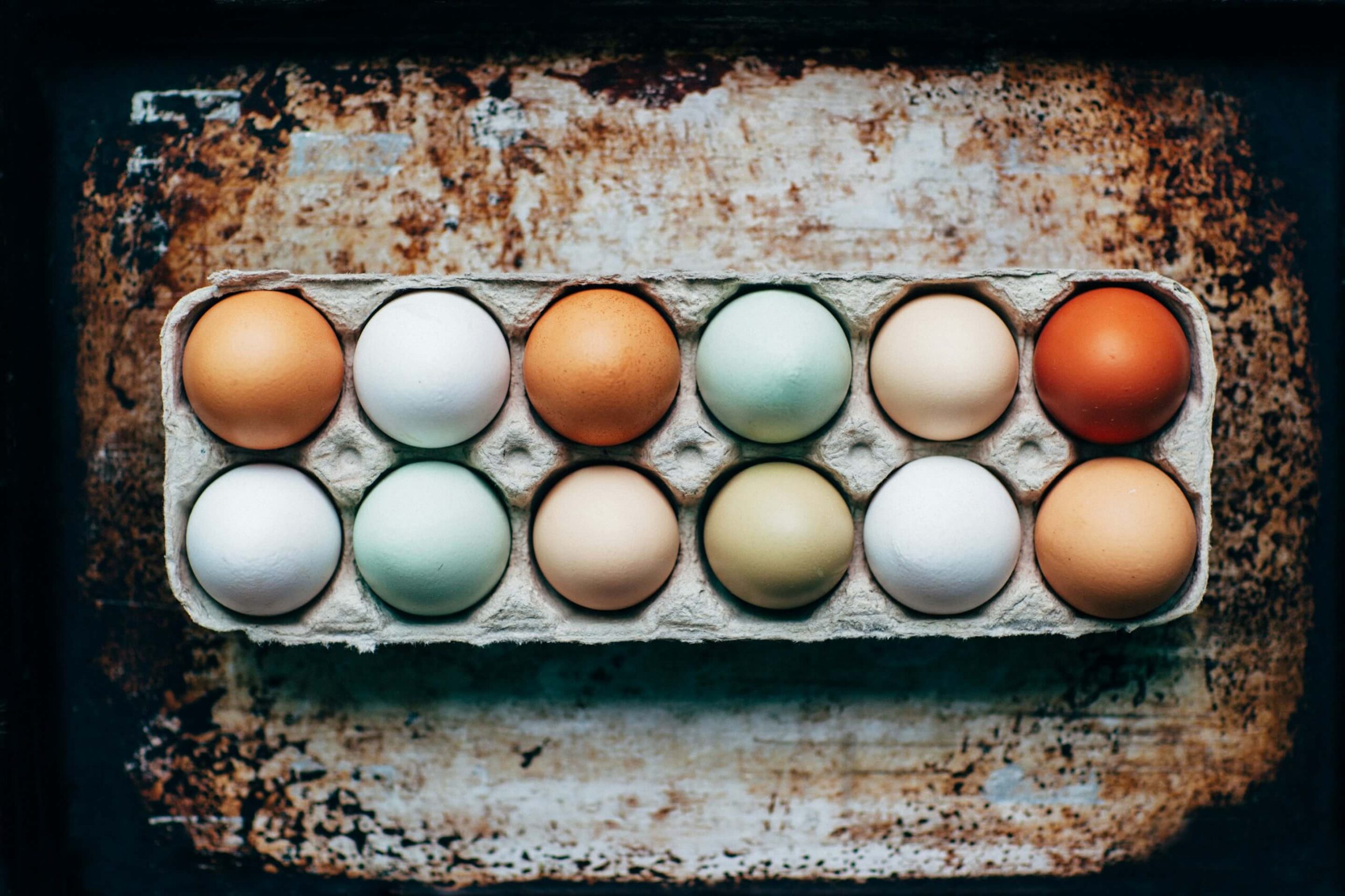 Eggs of various color in a carton