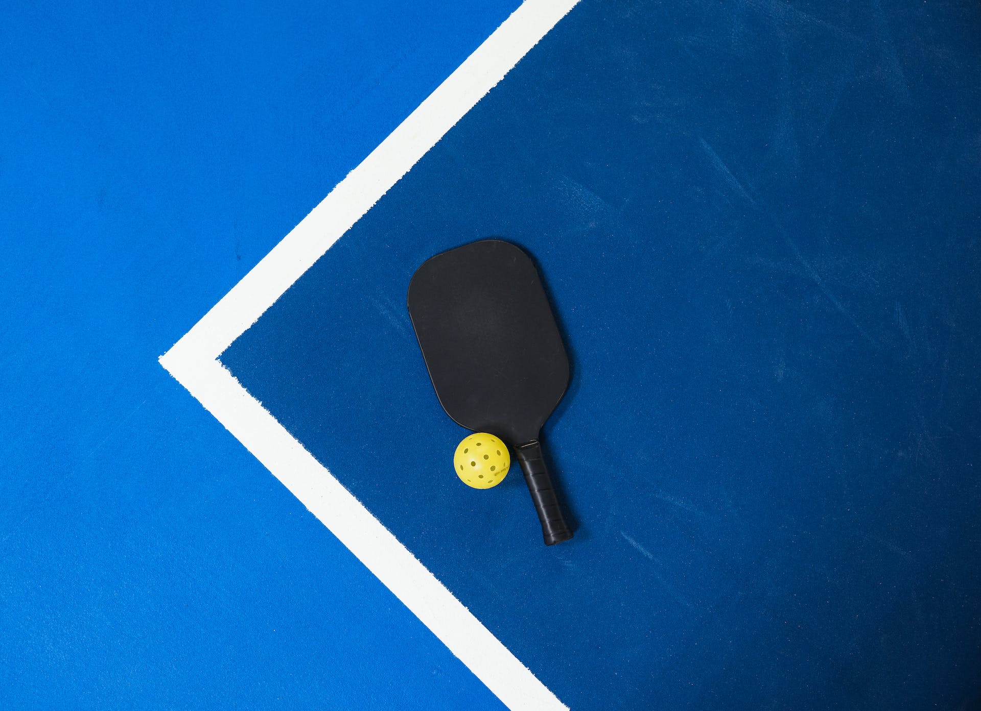 Paddle and ball on pickleball court