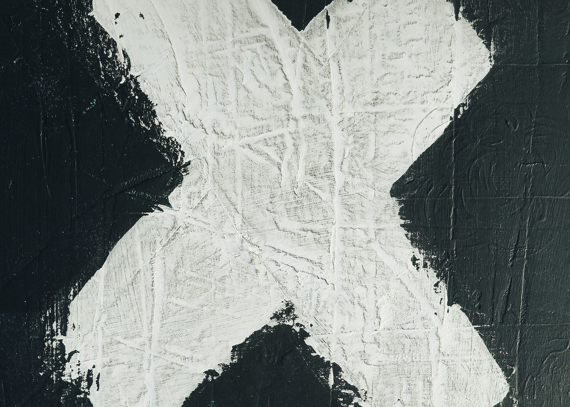 A white letter "X" painted on a black wall