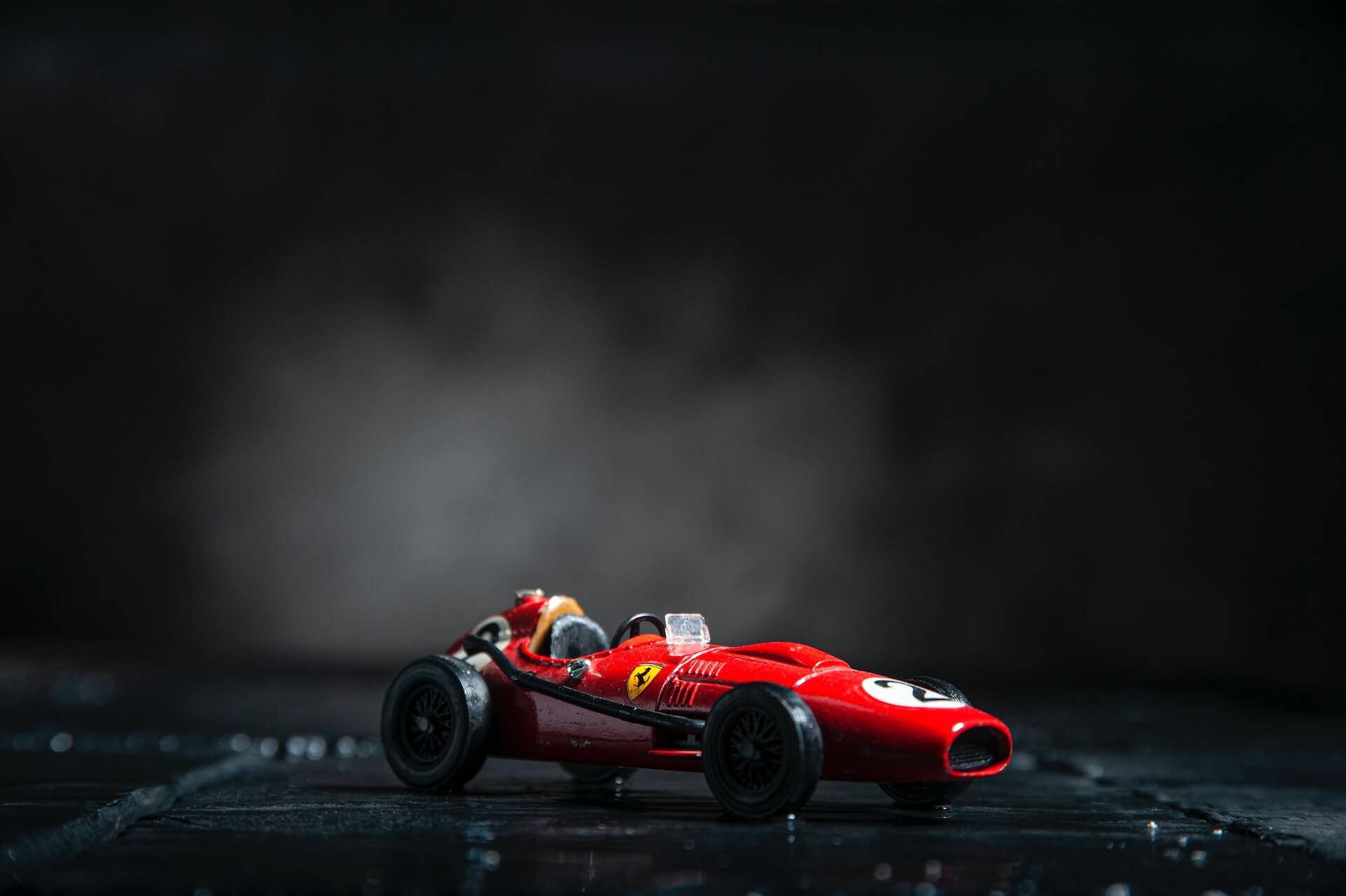 Red vintage model race car against black background