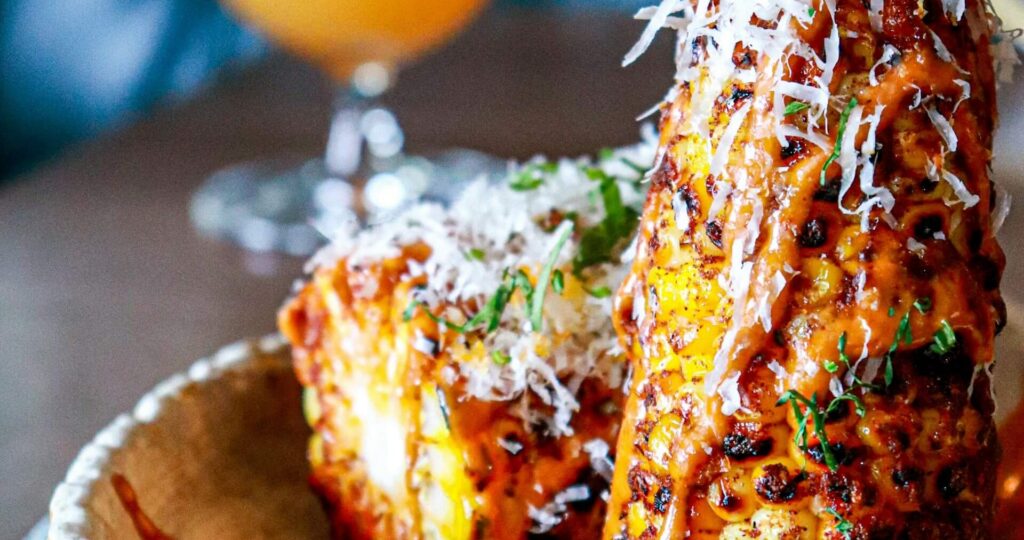 AleishaKalinaEloteStreetCornStyleDishOnTableUnsplashLandscape Elote or street corn-style dish on a table