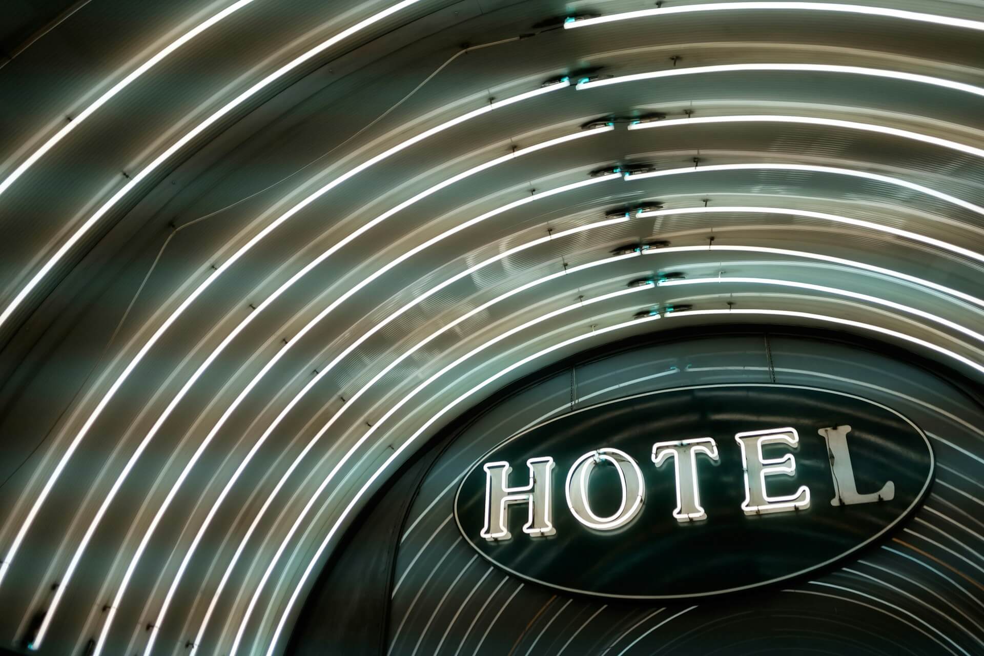 White neon sign that reads "HOTEL," with concentric white neon rings