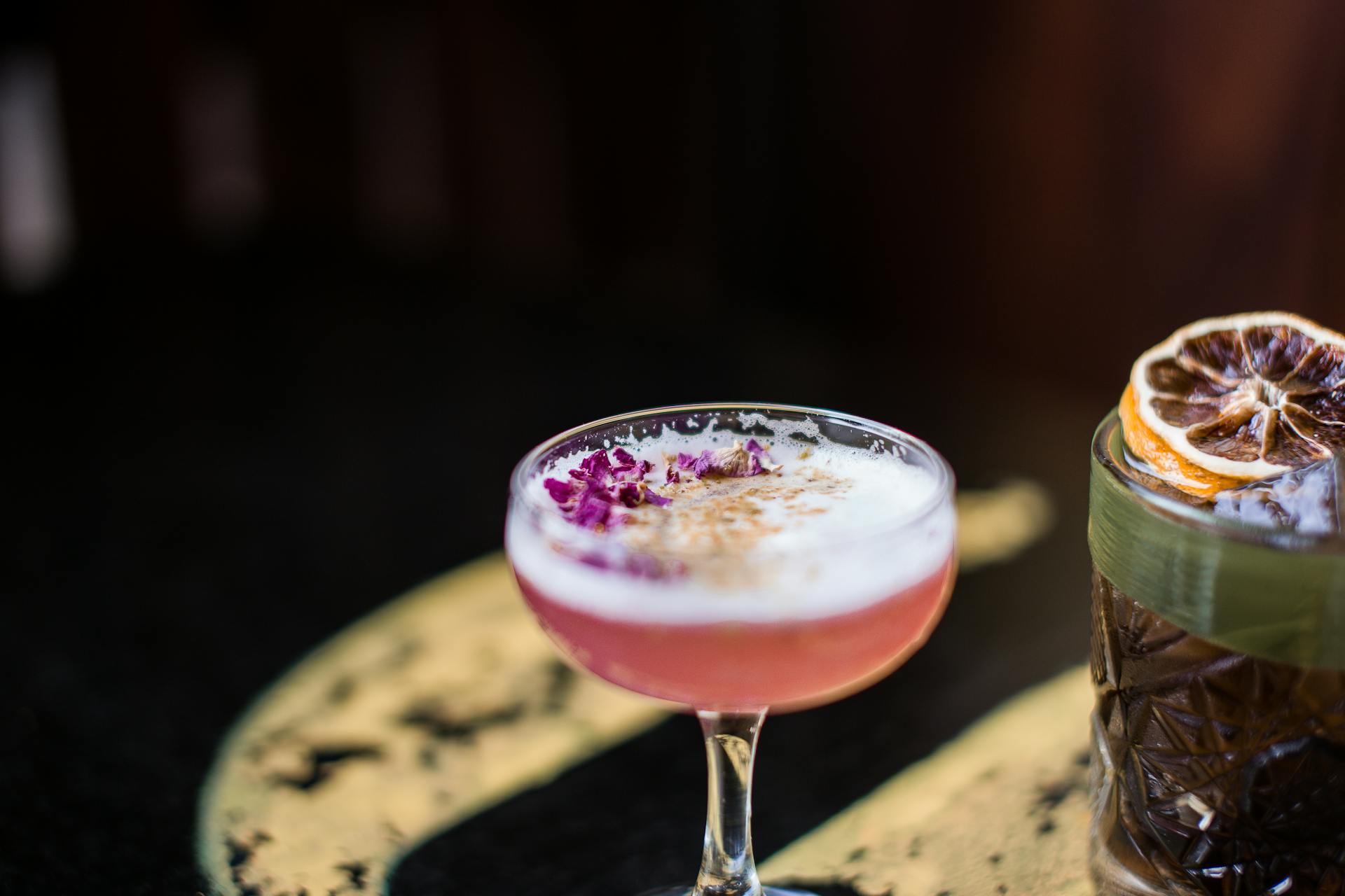 Cocktails with edible flowers and dehydrated fruit for garnishes