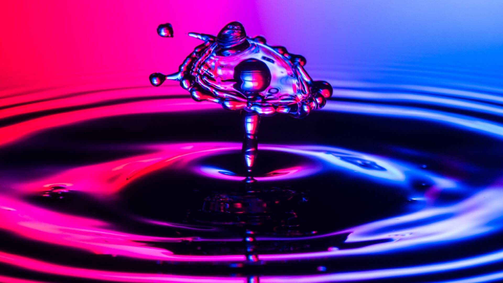 Red to purple color-shift background with splashing water droplet