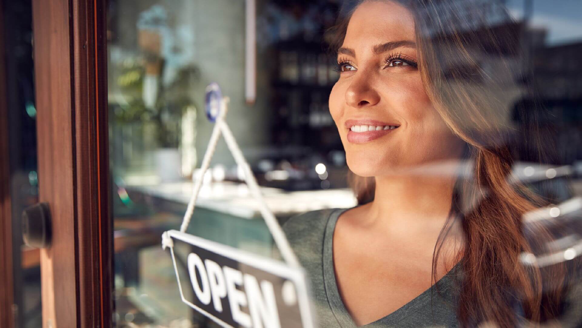 A restaurant or cafe owner flipping over the "open" sign on the door