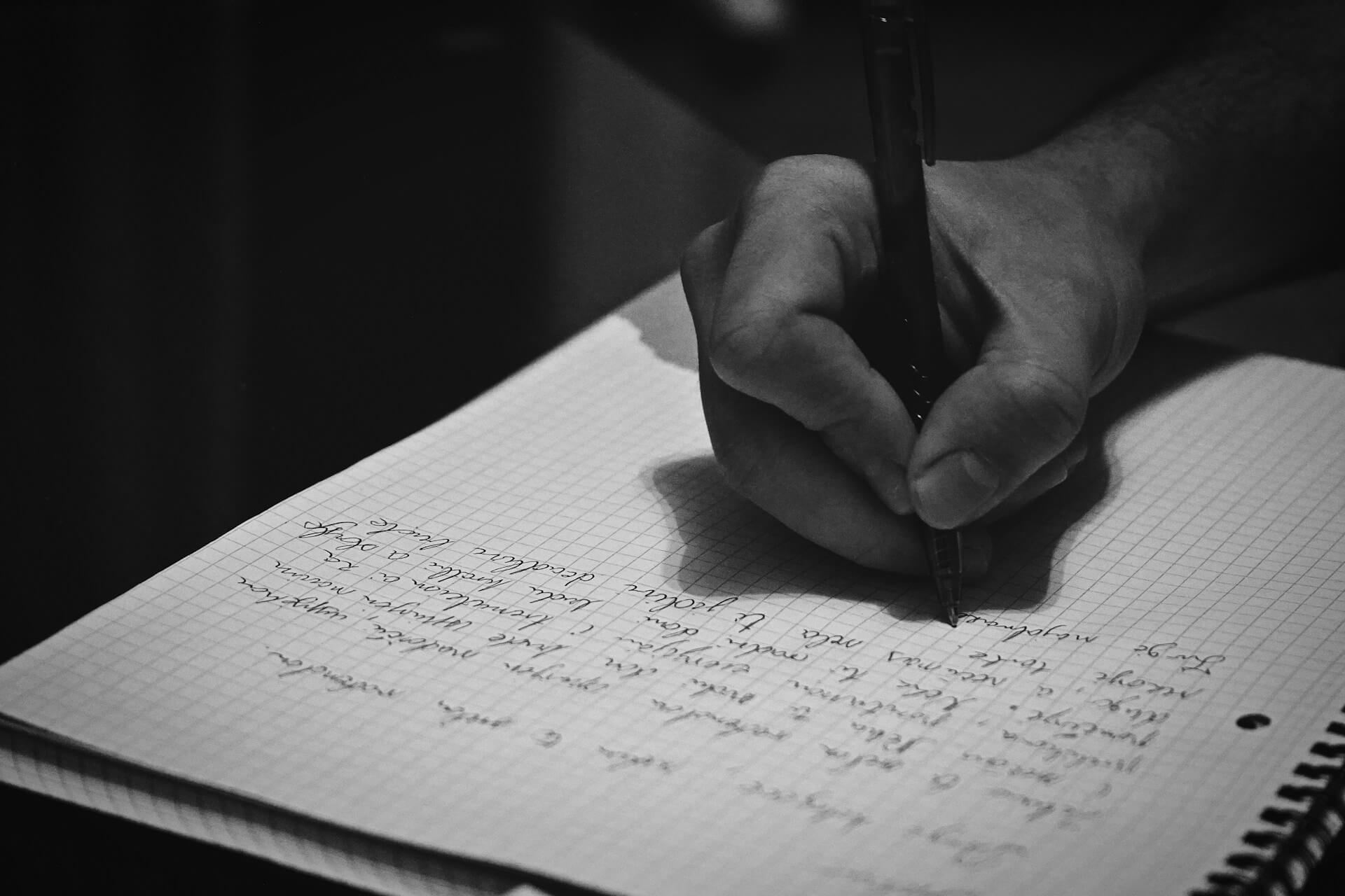 Hospitality founder writing self-interview questions in a notebook